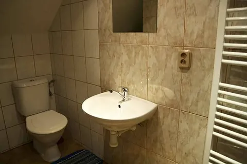 WC, umyvadlo a žebříkový radiátor v koupelně